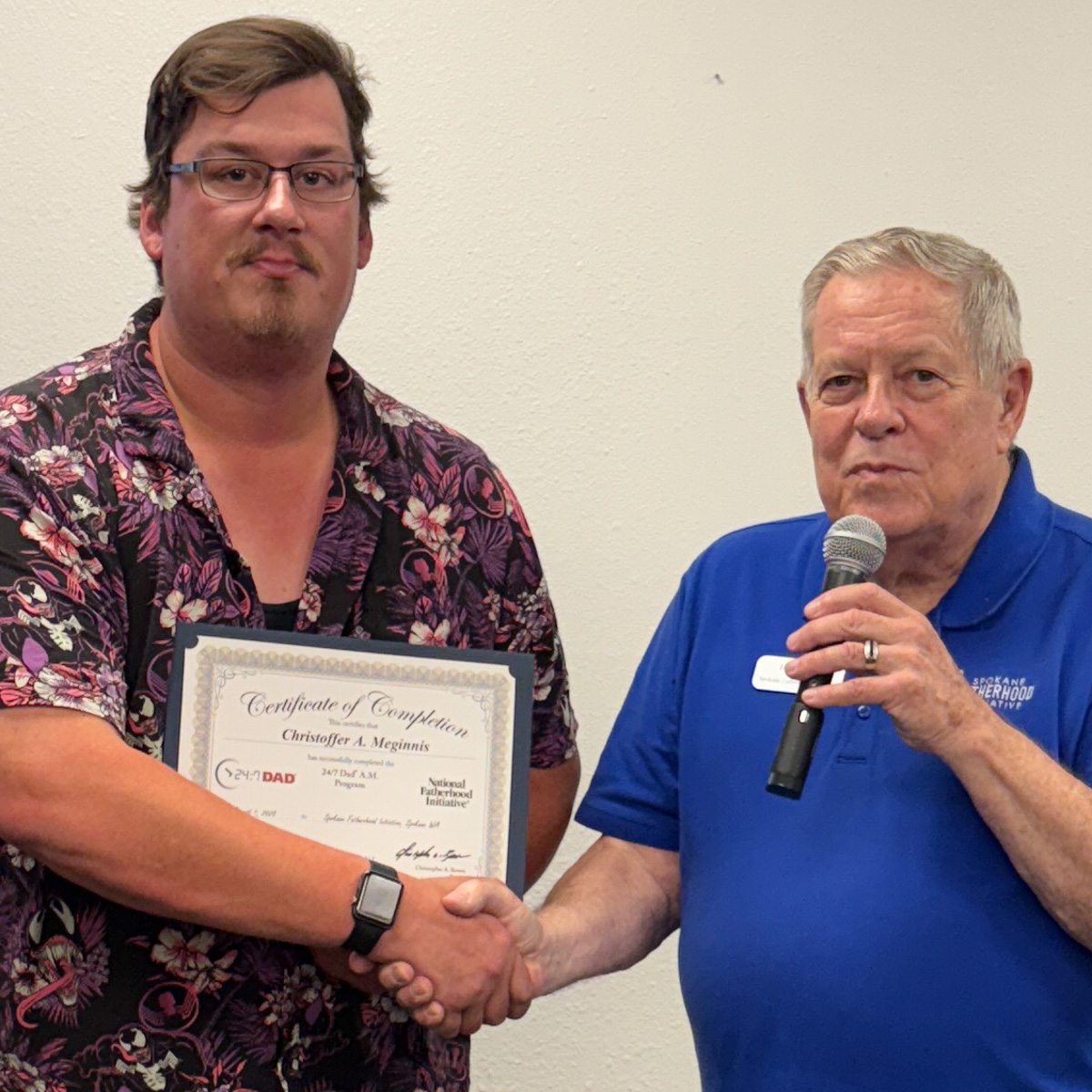 18 Spokane fathers graduate from 24-7 Dad® program: Another milestone in strengthening Spokane families 7 Father in floral print shirt shaking hands with instructor while holding graduation certificate