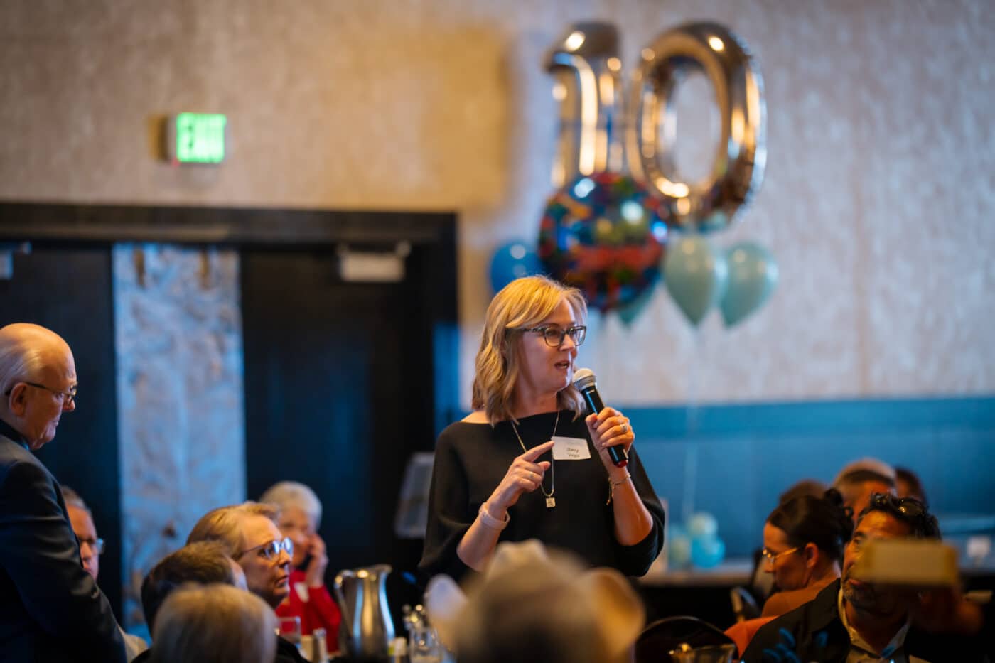Amy Vega speaks into a microphone at the SpoFI celebration banquet.