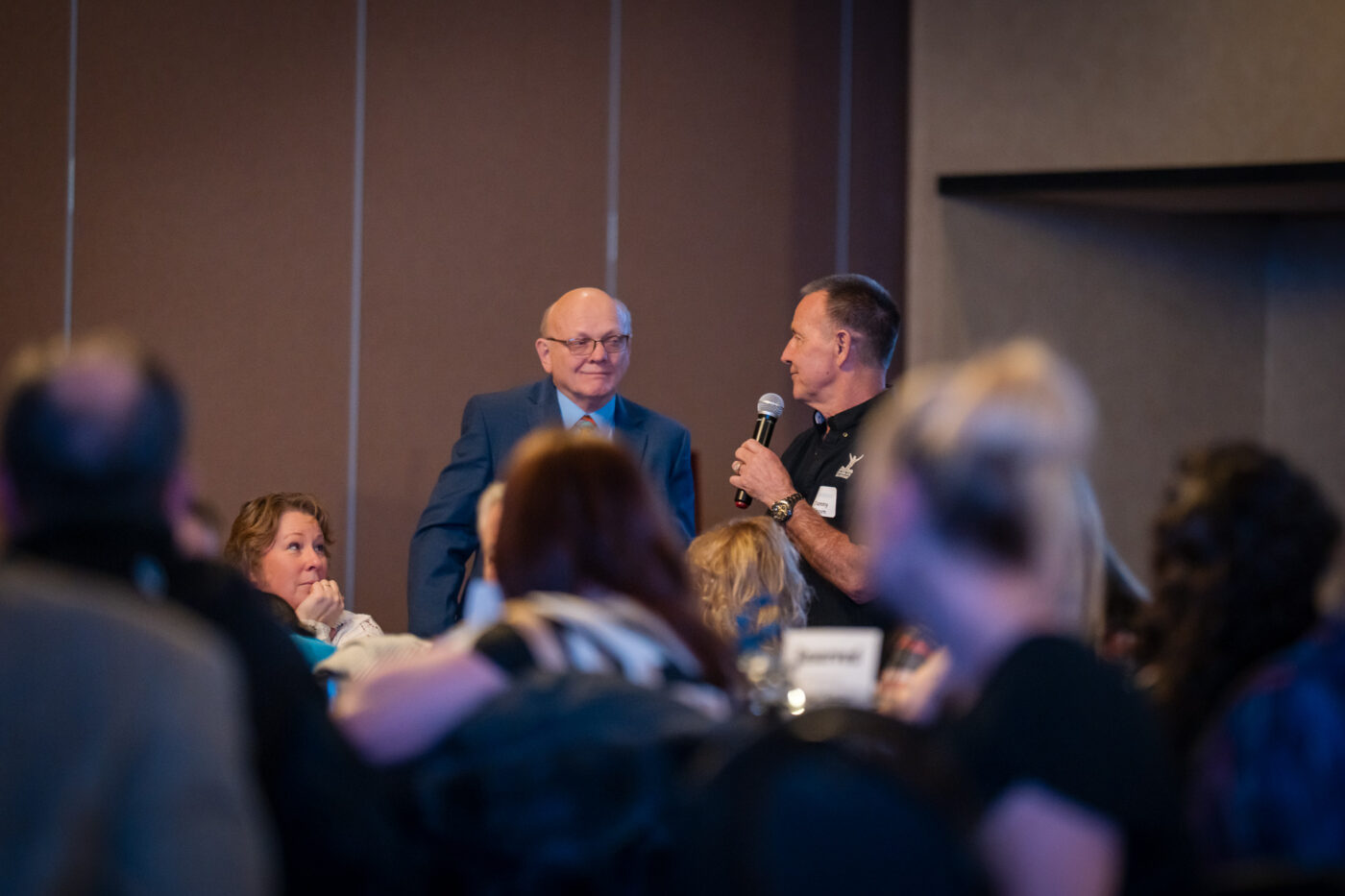 Danny Green speaks into a microphone while Ron Hauenstein stands beside him at the SpoFI 10th anniversary celebration.