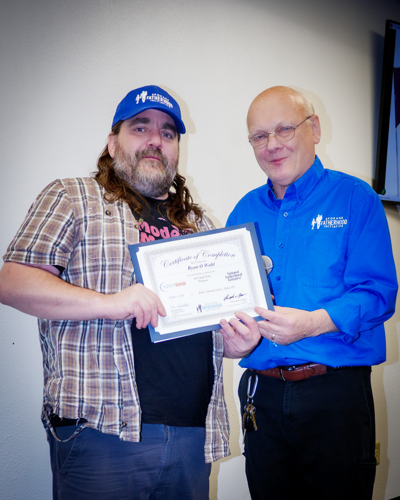 SpoFI Executive Director Ron Hauenstein congratulates a proud dad receiving his 24/7 Dad certificate.