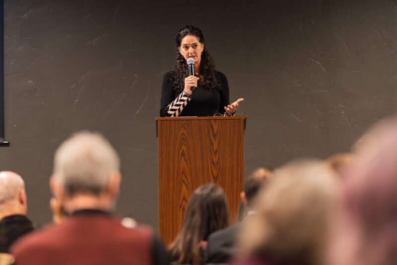 Superior Court Family Law Commissioner Michelle Ressa speaks at a podium during the Spokane Fatherhood Initiative's Building Legacy fundraiser, addressing an attentive audience of nearly 200 community members