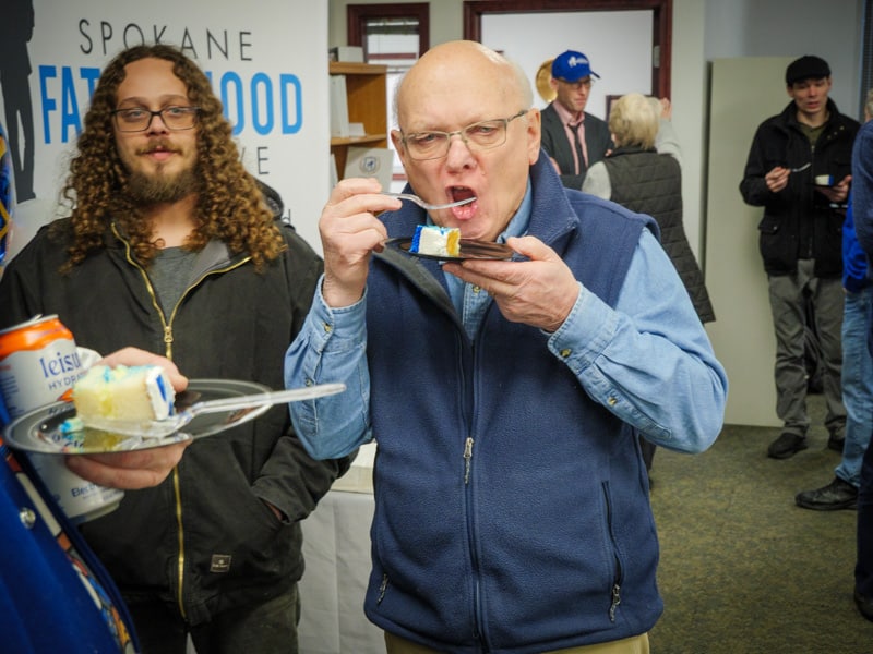 Ten years of changed dads: SpoFI celebrates a decade of transforming fathers and families 11 Jimmy Brewer SpoFI alumni and Ron Hauenstein founder enjoying cake at 10th anniversary celebration informal atmosphere January 2026 Spokane