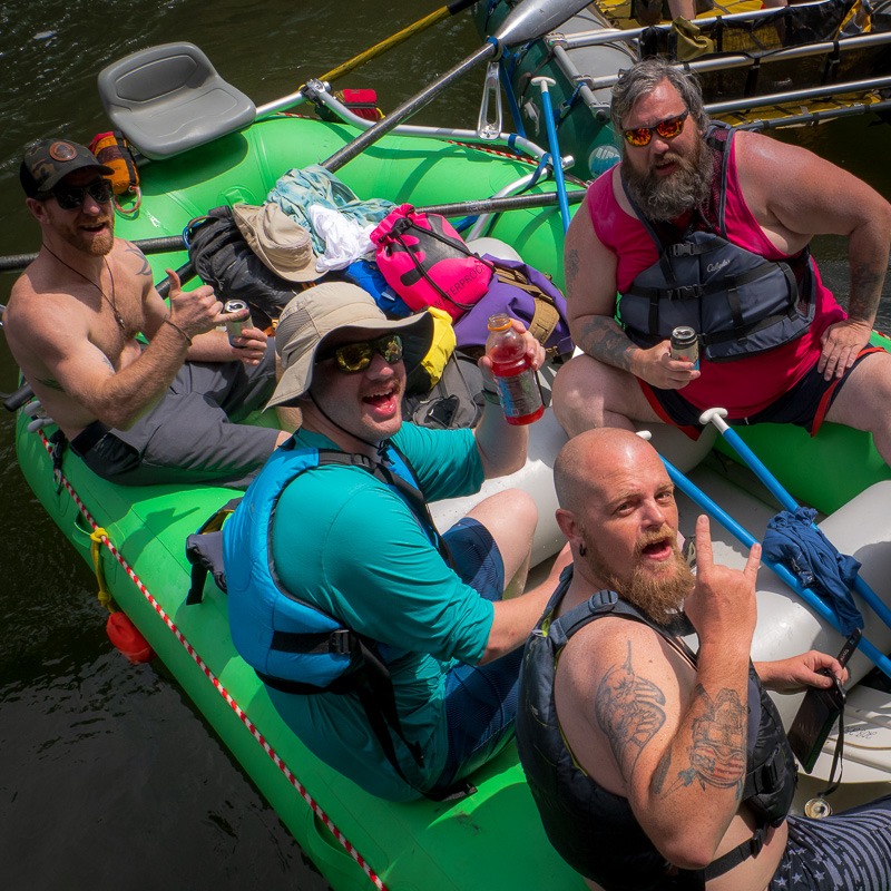 Four Dads AF alumni celebrating on a raft on the Clark Fork River during the 2024 Dads AF capstone whitewater rafting trip.