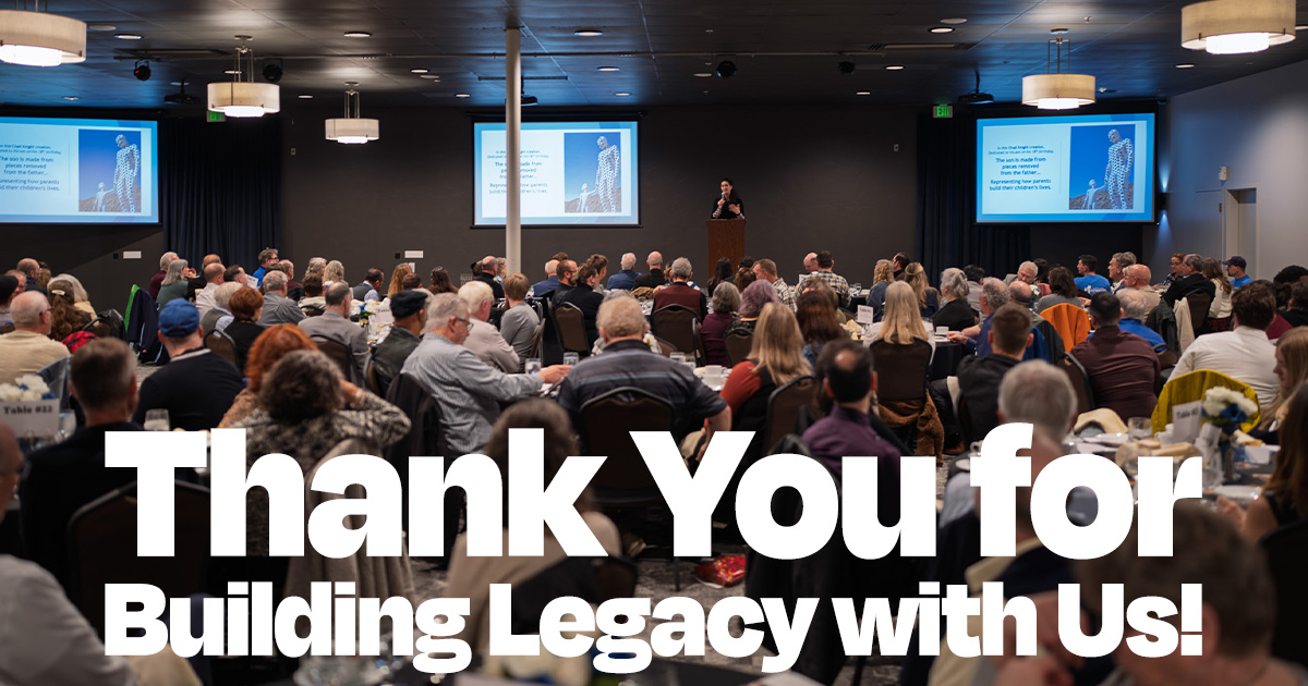 Building Legacy: Nearly 200 Gather to Celebrate Fatherhood and Family Transformation 1 Wide angle view of nearly 200 attendees seated at dinner tables facing a speaker at podium, with three large presentation screens displaying SpoFI's mission statement about fathers staying connected to their children, at the Building Legacy fundraiser event