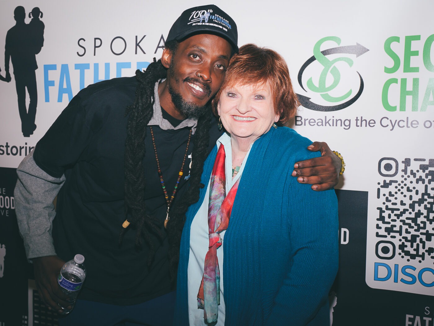 SpoFI's 100th 24-7 Dad class graduation recap: a night eight years in the making 26 Omari K., graduate of SpoFI's 100th 24-7 Dad class, with Carol Krum at the step-and-repeat photo backdrop at The Hive, April 10, 2026