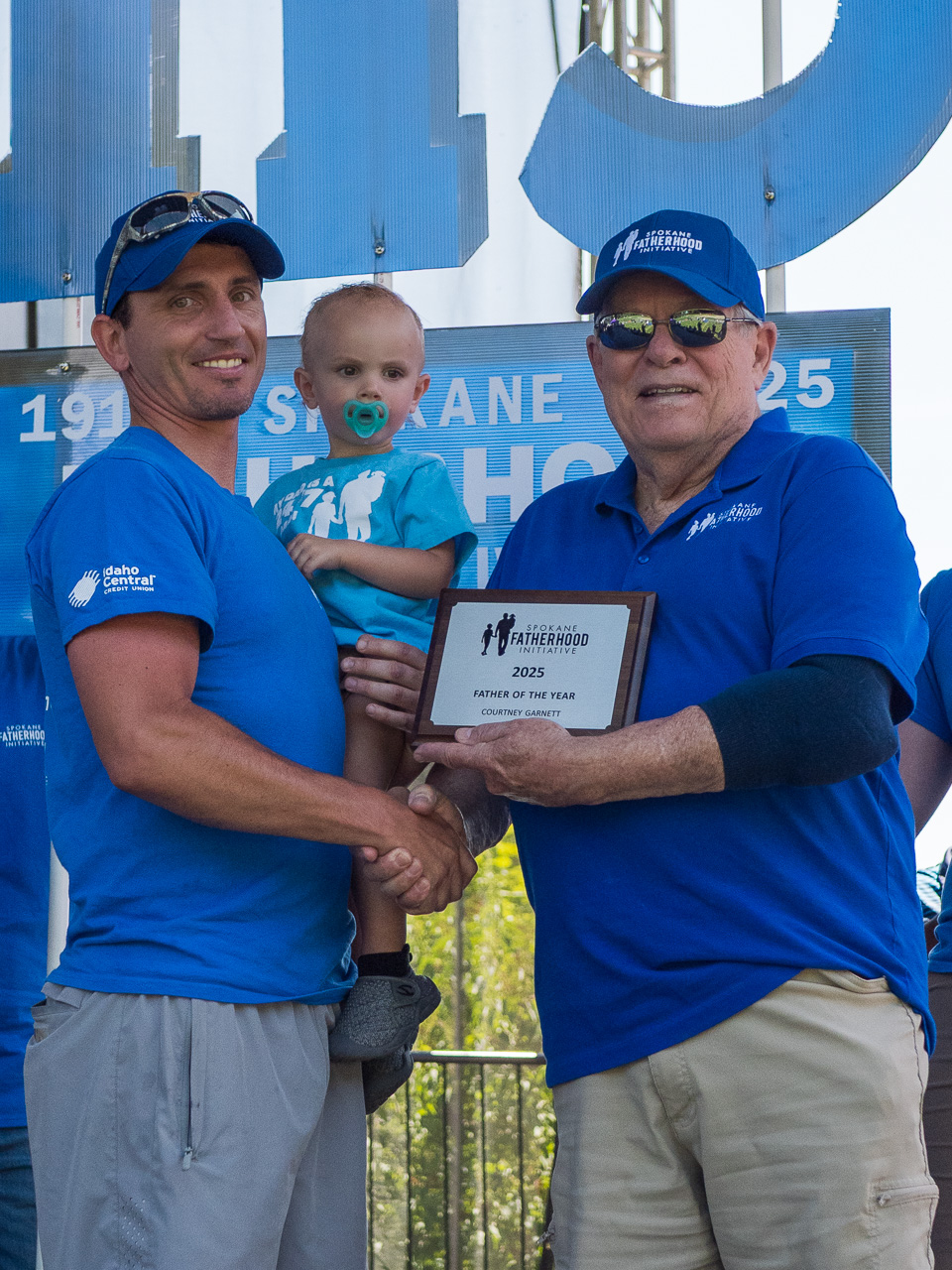 SpoFI Honors Outstanding Fathers at Annual Father's Day Celebration 3 Non-Custodial Father of the Year Courtney Garnett poses with his son and SpoFI award plaque at 115th anniversary Father's Day celebration