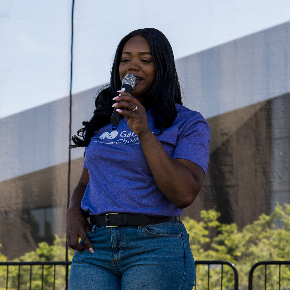 Community connection strengthens Spokane families at Father's Day celebration 2 Kitara Jones-Johnson speaks about Gabriel's Challenge while wearing blue Gabriel's Challenge shirt at Riverfront Park