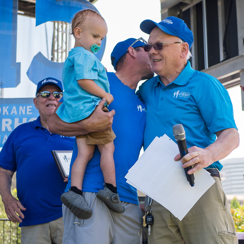 Community connection strengthens Spokane families at Father's Day celebration 14 Courtney Garnett whispers words of gratitude to Ron Hauenstein while holding his baby during his walk to receive the 2025 Non-Custodial Father of the Year award