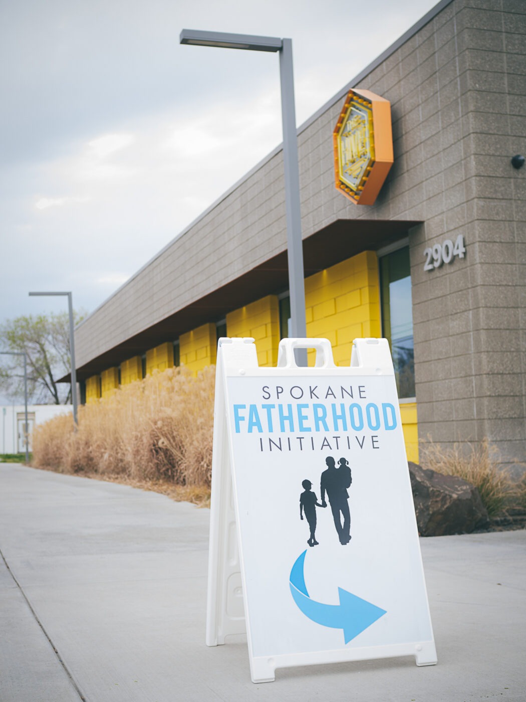 SpoFI's 100th 24-7 Dad class graduation recap: a night eight years in the making 2 Spokane Fatherhood Initiative A-frame sign outside The Hive at 2904 E Sprague Ave, Spokane — venue for the 100th 24-7 Dad graduation, April 10, 2026
